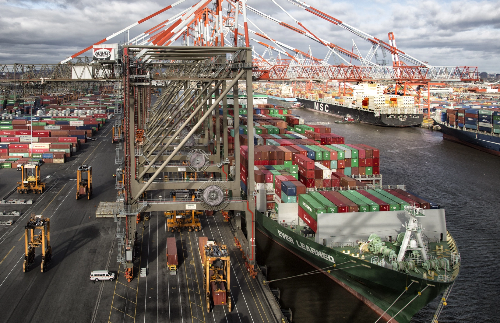 Ship-to-shore crane loading containers at Maher Terminals in a busy port environment