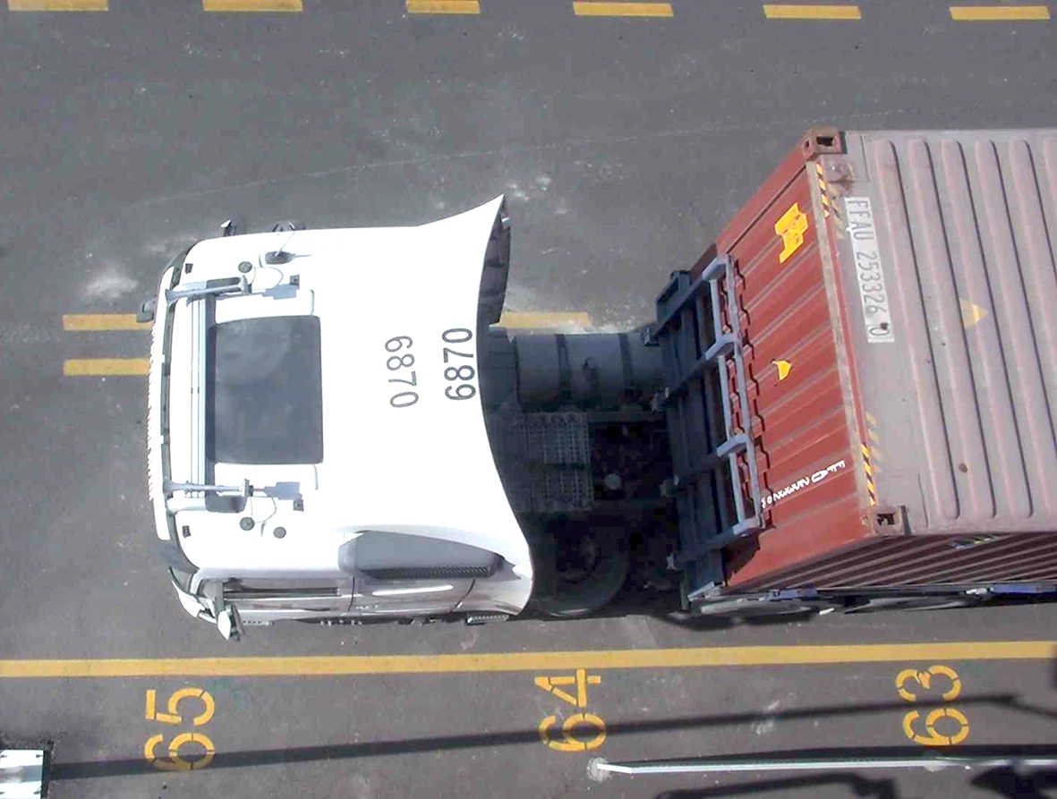 Terminal tractor under yard crane with rooftop number clearly visible for OCR identification